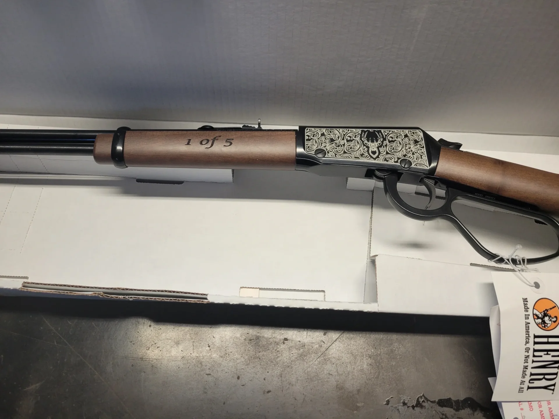 Lever-action rifle with engraved metal plate.