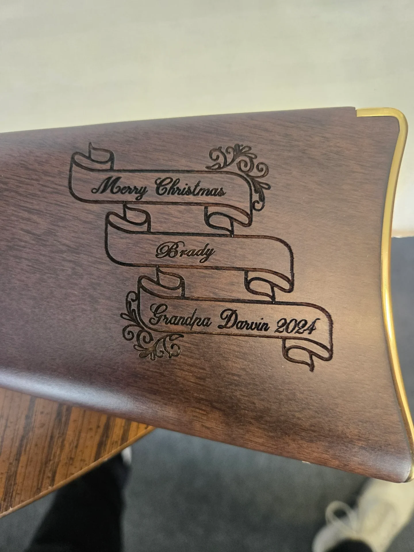 Engraved wooden object with decorative text.