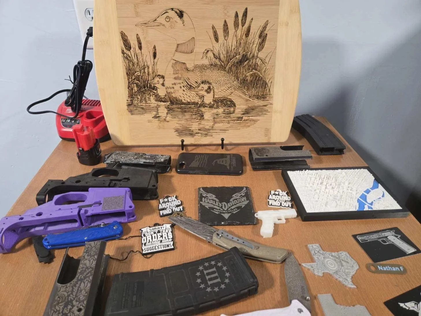 Wooden engraving and assorted gun components on table.